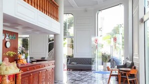 A lobby with a marble floor, a reception desk, a sofa, and a seating area with chairs. - Blue Ocean Hotel Phan Thiet - BAY LUXURY (Phu Thuy)