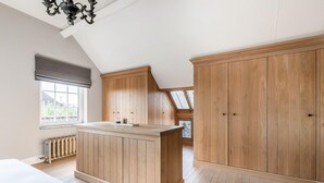 A spacious room with a large wooden wardrobe, a built-in kitchen island, and a skylight. - Luxury Retreat with furry friends (Alken)