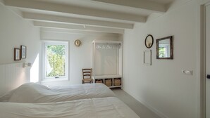 Un dormitorio con dos camas, una ventana, un armario y un espejo.