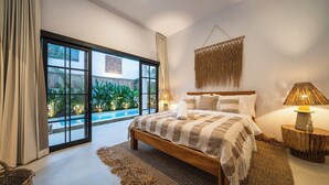 Une chambre avec un grand lit, une vue sur une piscine et un élément décoratif suspendu au mur.