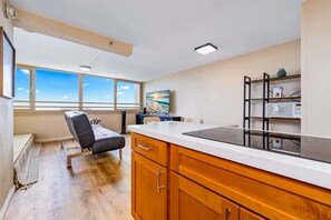 Une cuisine moderne avec des meubles en bois, une chaise noire et une grande fenêtre donnant sur un beau paysage.