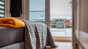 Une chambre avec un lit, une fenêtre et une vue sur un balcon.