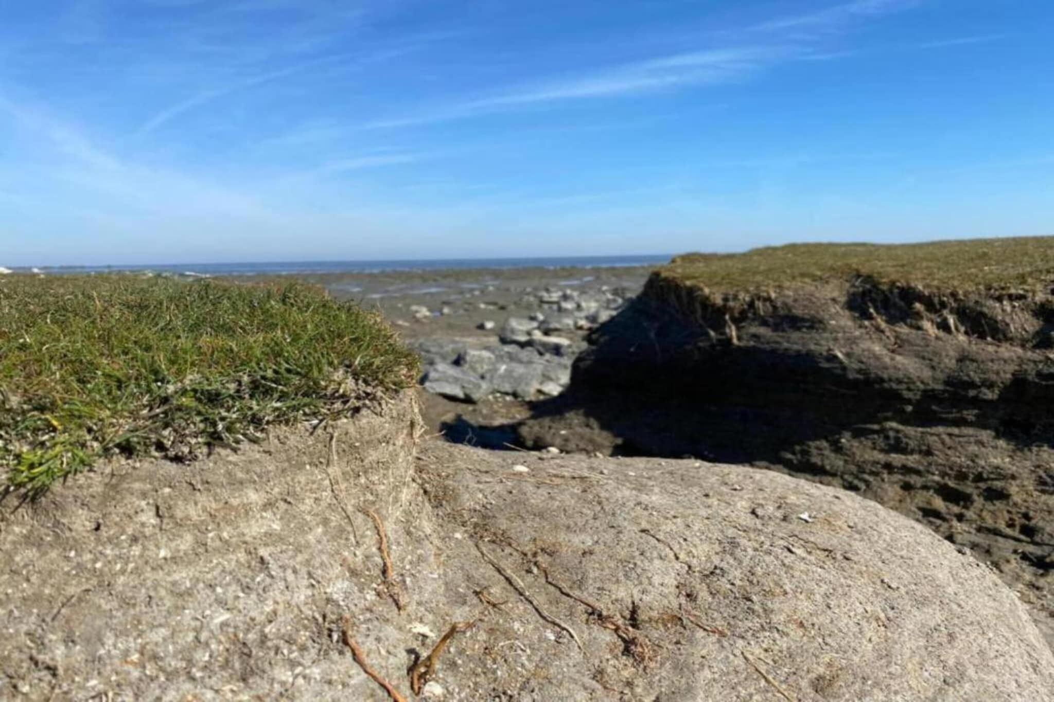Een rotsachtig kustlandschap met een heldere lucht.
