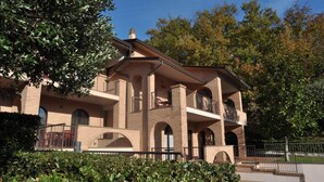 A multi-story building with a brick facade, balconies, and arched windows. - Holiday Home near Mount Subasio (Assisi)