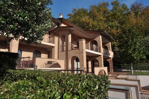 A multi-story building with a brick facade, balconies, and arched windows. - Holiday Home near Mount Subasio (Assisi)