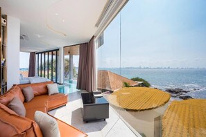 A modern living room with a large window overlooking a coastal view. - MADUSEA GRAND VILLA  (Koh Lan)