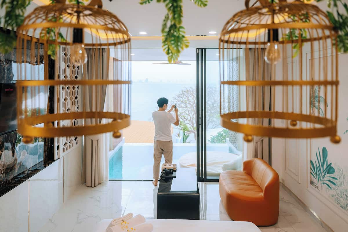 Un intérieur moderne avec une porte vitrée donnant sur un balcon, un canapé et un téléviseur sur le mur de gauche.