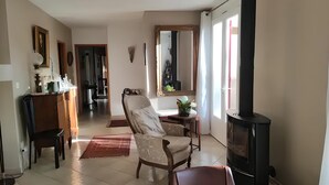 Ein Wohnzimmer mit Kamin, einem Essbereich und einem Flur, der in einen anderen Raum führt.