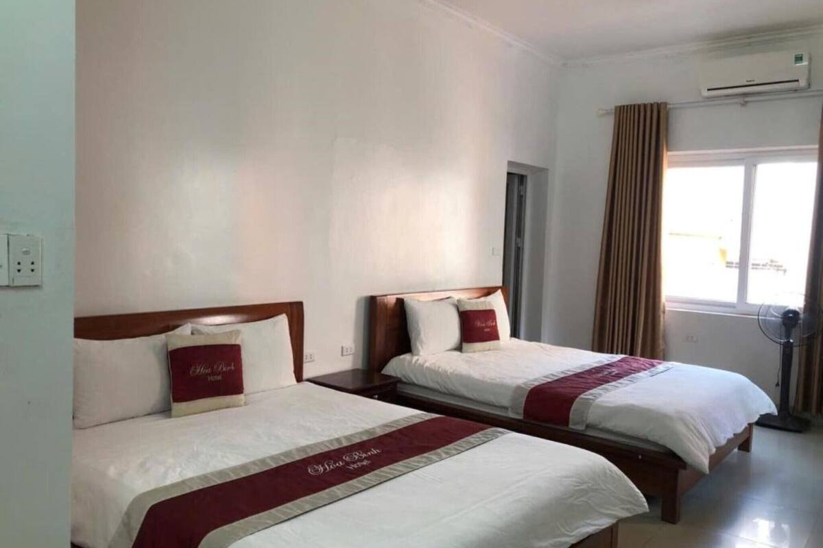 Two single beds with wooden headboards, white bedding, and red accents.