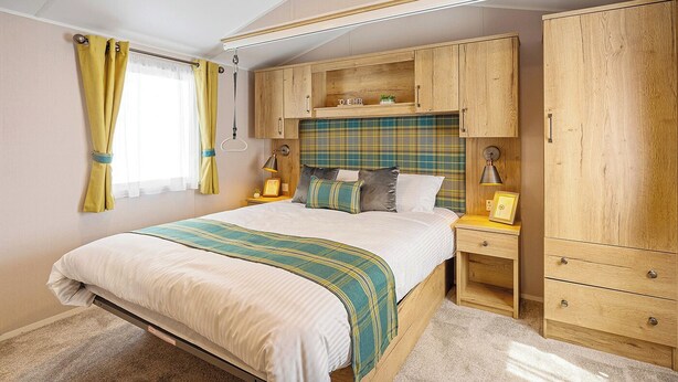 A bedroom with a bed, bedside tables, a wardrobe, and a ceiling light.