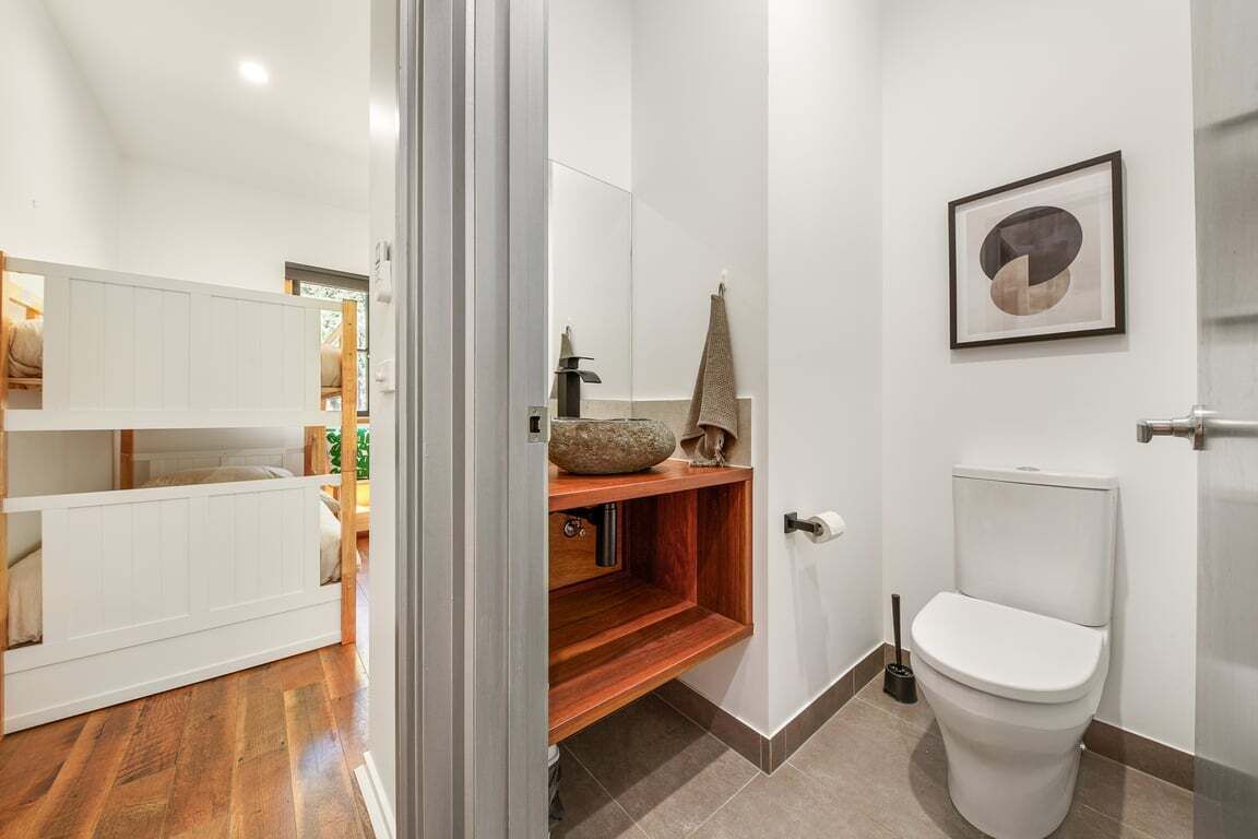 A modern bathroom with a toilet, a sink, and a shower area.