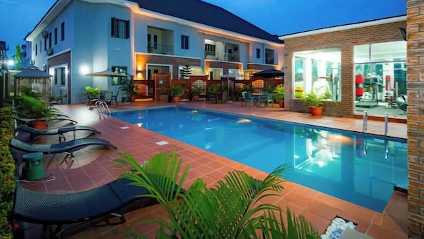 A hotel with a swimming pool, outdoor seating, and a fitness center. - D'Stolz Villa and Hospitality (Abuja)