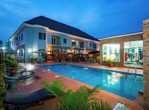 A hotel with a swimming pool, outdoor seating, and a fitness center. - D'Stolz Villa and Hospitality (Abuja)