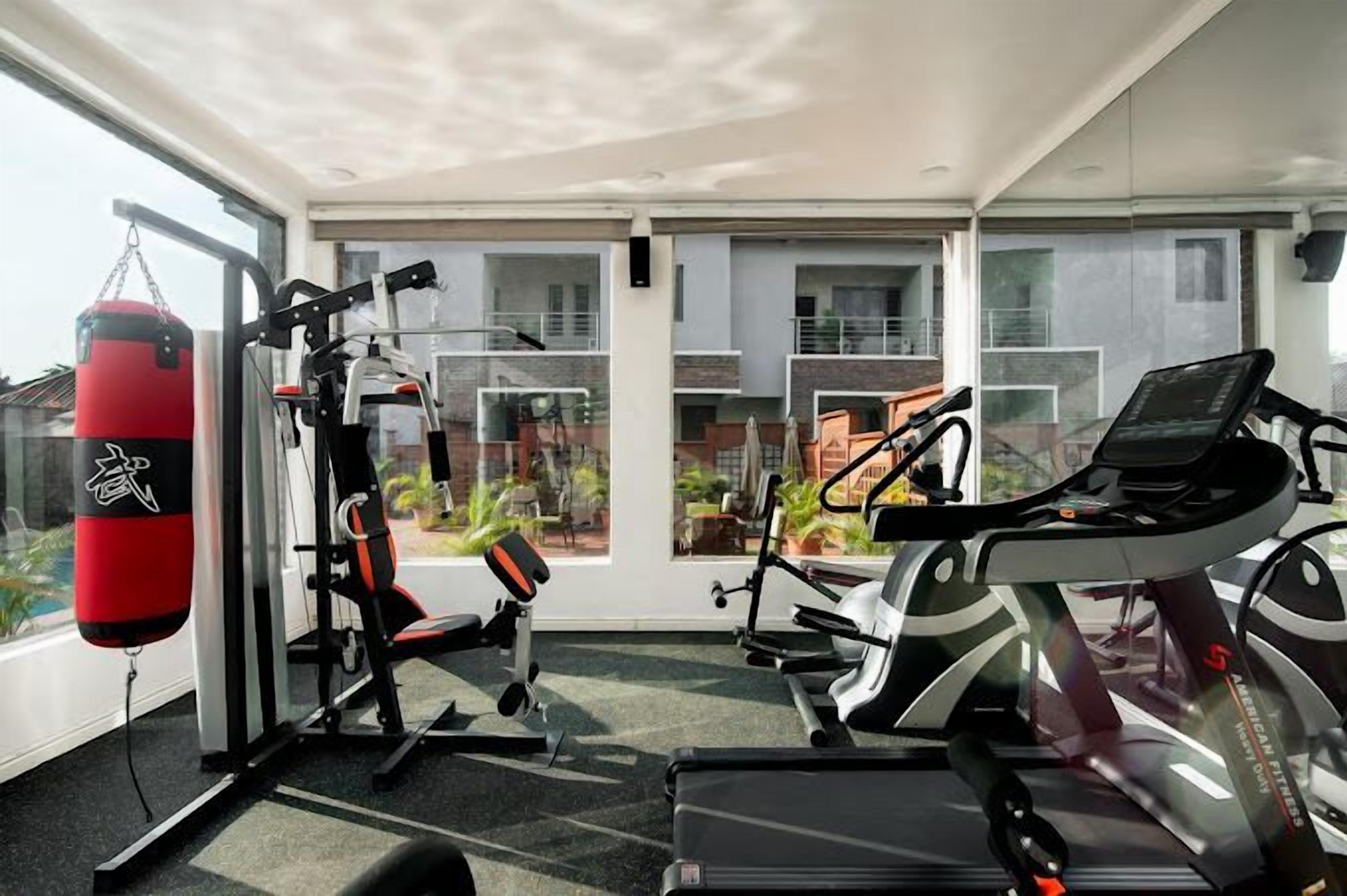 A gym with cardio equipment, weight machines, and a punching bag.