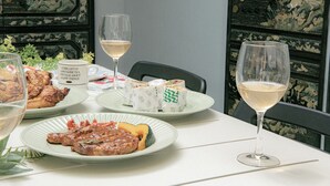 Et spisebord med tallerkener med mad, vinglas og en dekorativ væg.