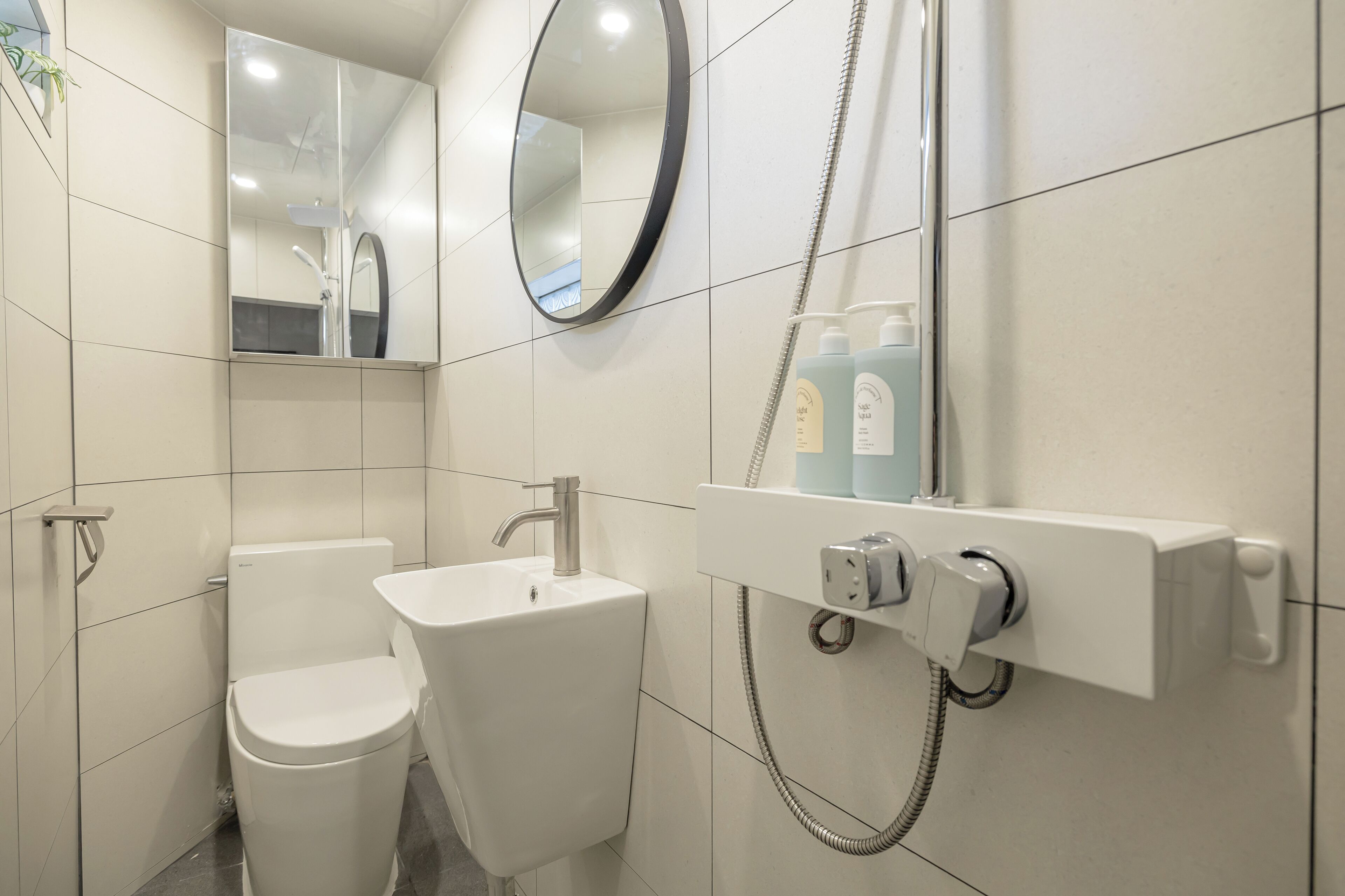A modern bathroom with a toilet, sink, and shower unit.
