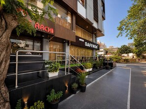 A modern building with a sign for 'ARCHI' and 'SAFFRON'. - HOTEL THE ARCHI (Udaipur)