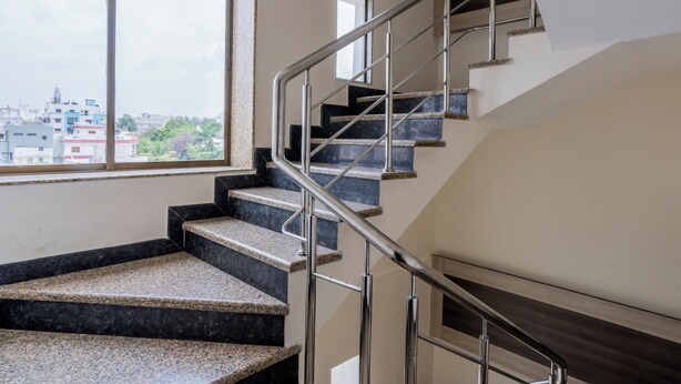A modern staircase with metal railings and granite steps, leading to an upper floor. - HOTEL THE ARCHI (Udaipur)