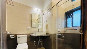 A bathroom with a toilet, sink, and glass shower enclosure. - HOTEL THE GRAND AGASTYA (Singrauli)