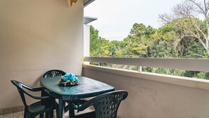 Ein Balkon mit Tisch und Stühlen, mit Blick auf Bäume.