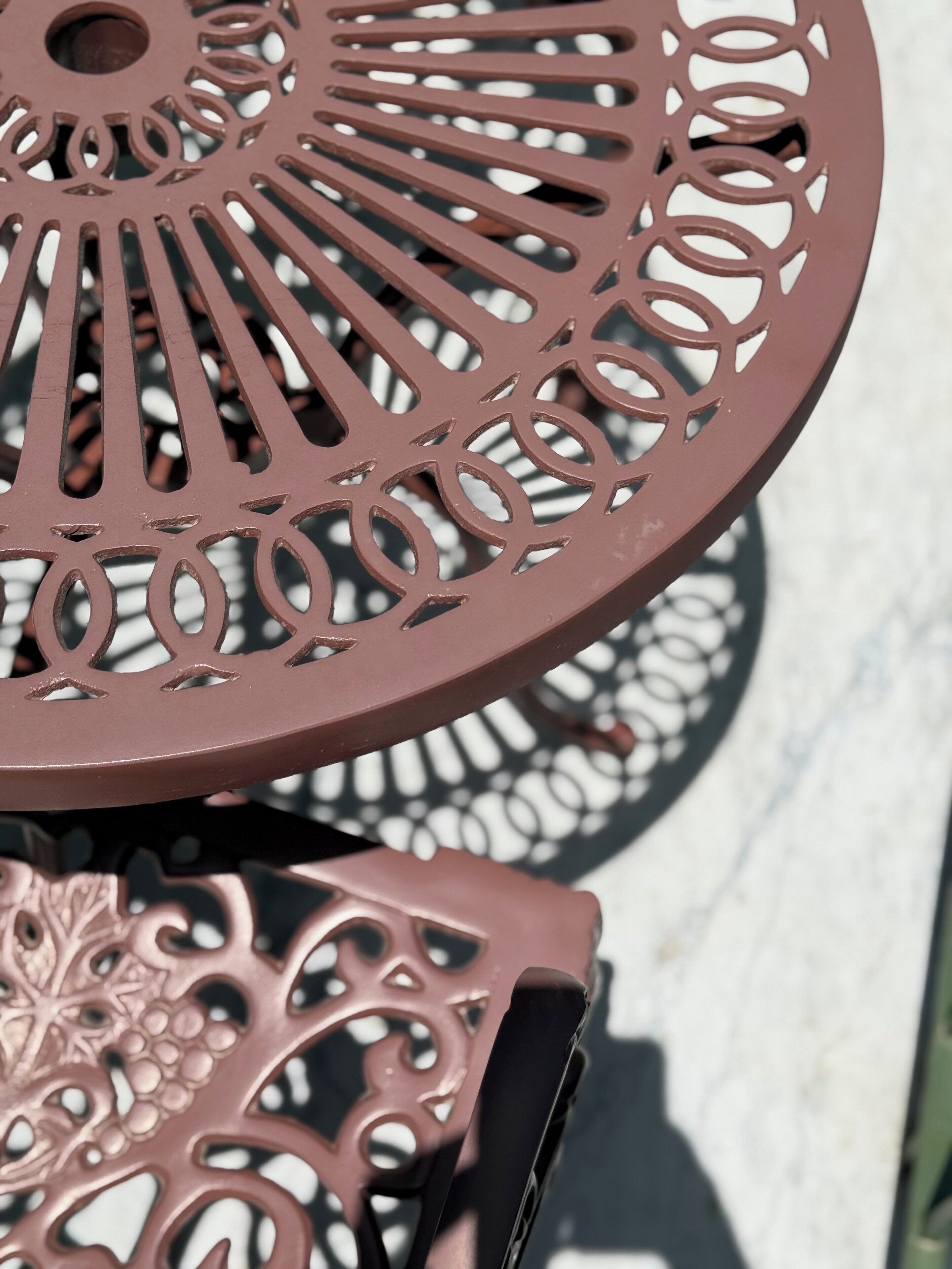 Un gros plan d’une table en métal ornée de motifs complexes découpés.