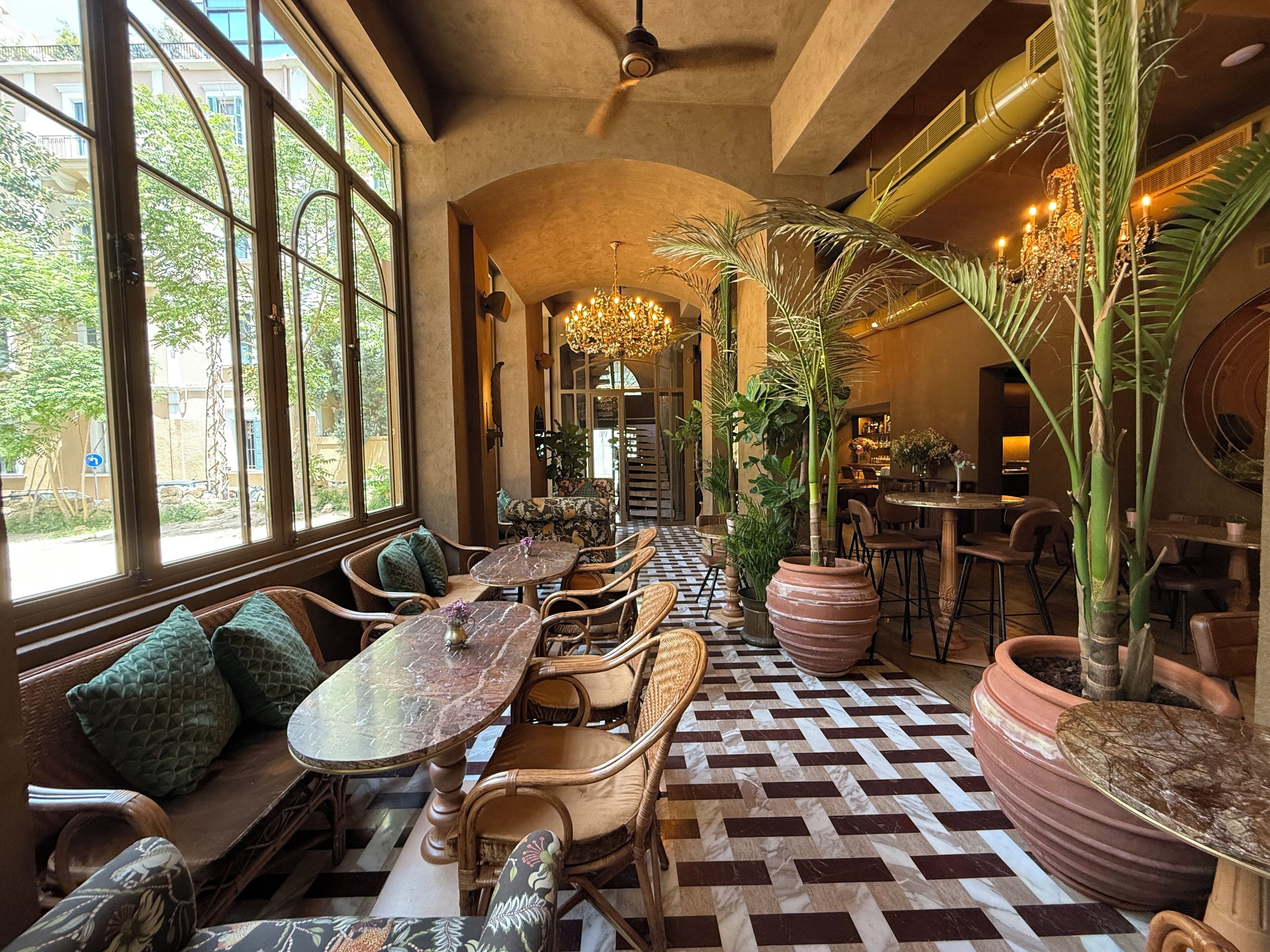A restaurant with high ceilings, large windows, and a patterned floor.