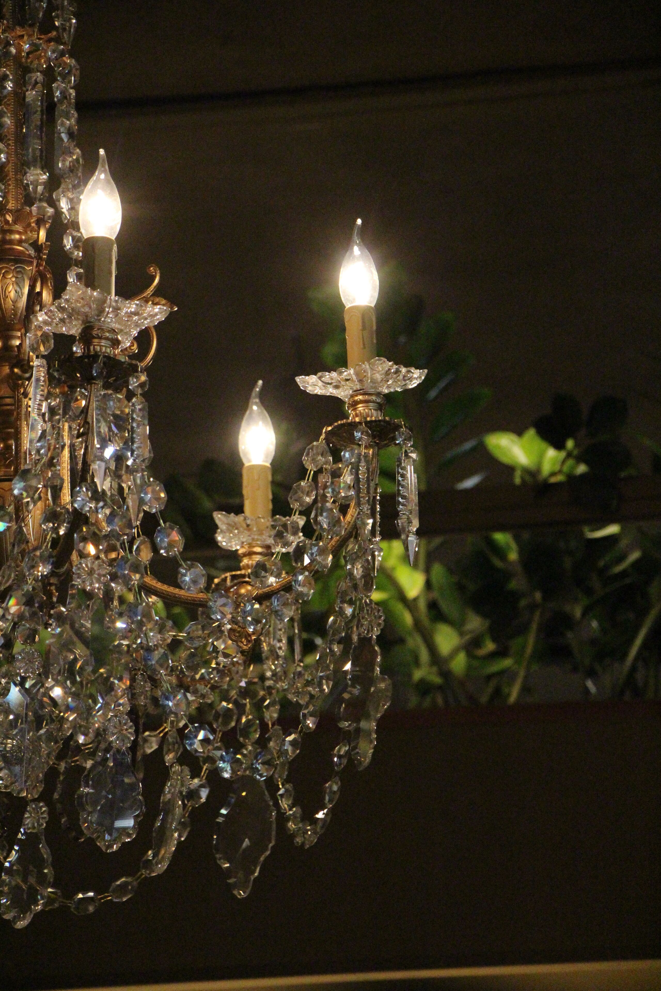 A chandelier with multiple candle-like lights and crystal decorations.