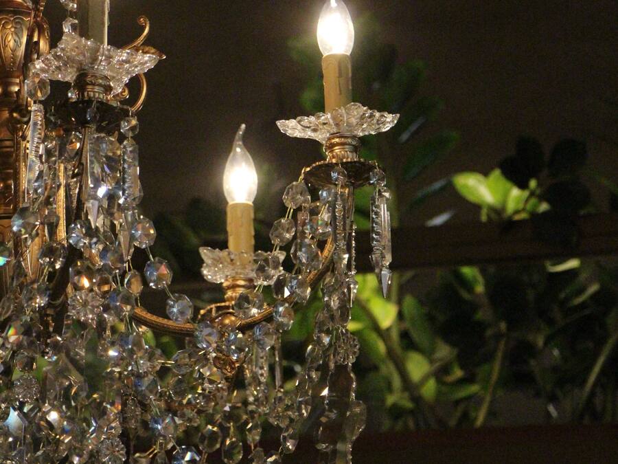 A chandelier with multiple candle-like lights and crystal decorations.