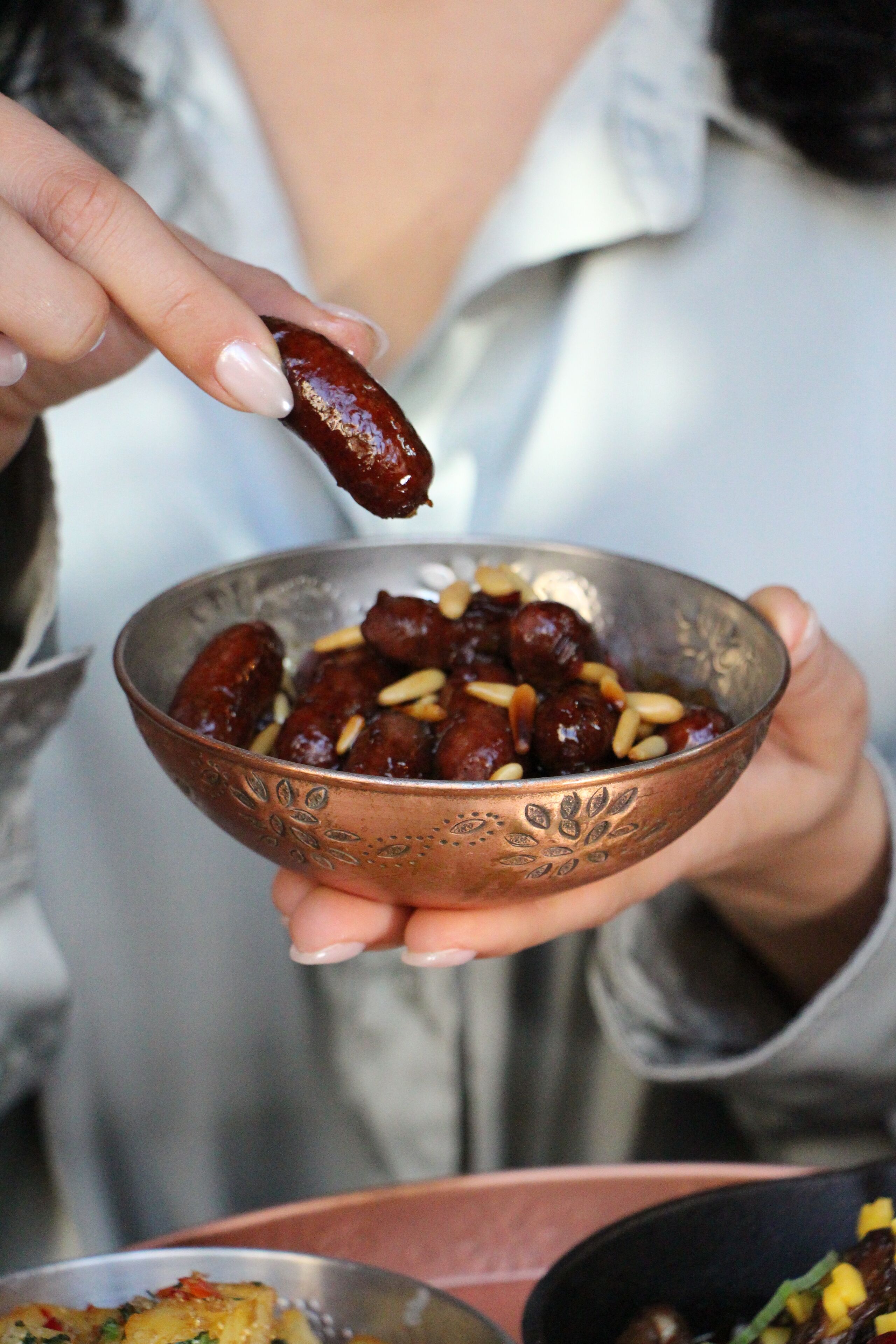 Una persona sosteniendo un tazón con dátiles y nueces.