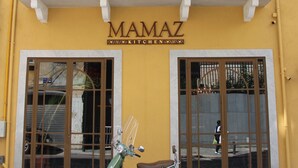 Un bâtiment jaune sur lequel on peut lire l’inscription « MAMAZ KITCHEN ».