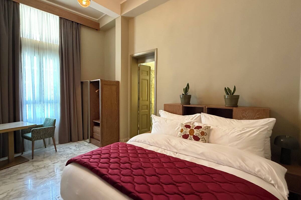 Une chambre d’hôtel comprenant un lit, un bureau, une chaise et une armoire.