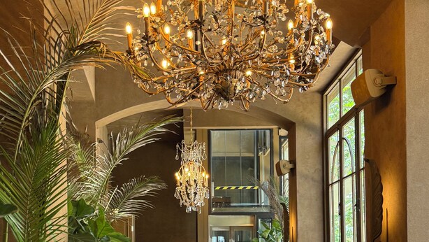 Un intérieur chaleureux avec un sol à motifs, des sièges confortables et un lustre décoratif.