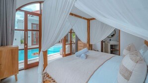 A bedroom with a canopy bed, a view of a swimming pool, and a wooden dresser.