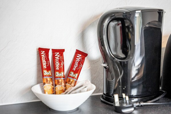 A white bowl with three packets of Nespresso coffee and a black coffee maker on a kitchen counter. - Camberwell Studios, 10 mins to Station (London)