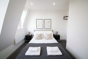 A modern bedroom with a large bed, two bedside tables, and a window. - Stylish 2BR Apartment Near Preston City Centre (Preston)