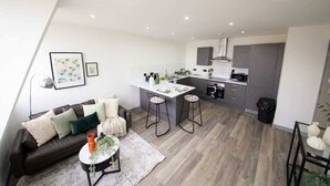 A modern apartment with a kitchen, dining area, and living room. - Stylish 2BR Apartment Near Preston City Centre (Preston)