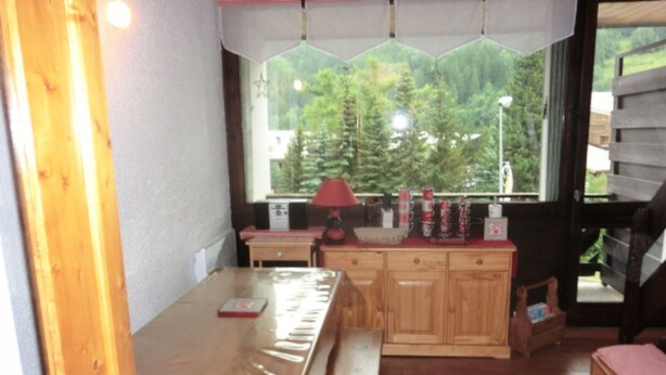 A wooden interior with a bench, a table, and a window with a view of trees. - Duplex 6 Guests, Near Ski Slopes, Balcony, Pet-Friendly (Saint-Chaffrey)