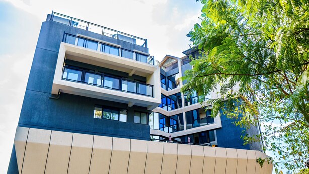 A multi-story building with a modern architectural design, featuring balconies and large windows. - The Moon Apartment-Luxurious modern 2-bedroom apartment in Kigali (Kigali)