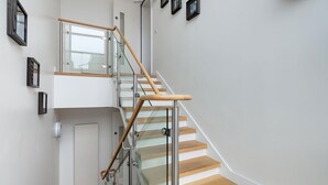 Una escalera moderna con barandillas de vidrio y escalones de madera.