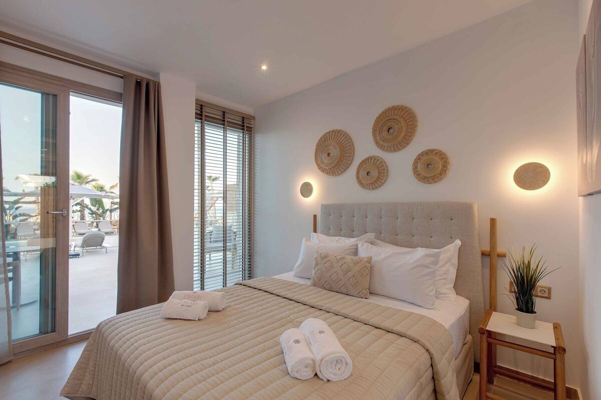 Une chambre d’hôtel avec un grand lit, une vue sur l’espace extérieur et un mur décoré d’œuvres d’art.