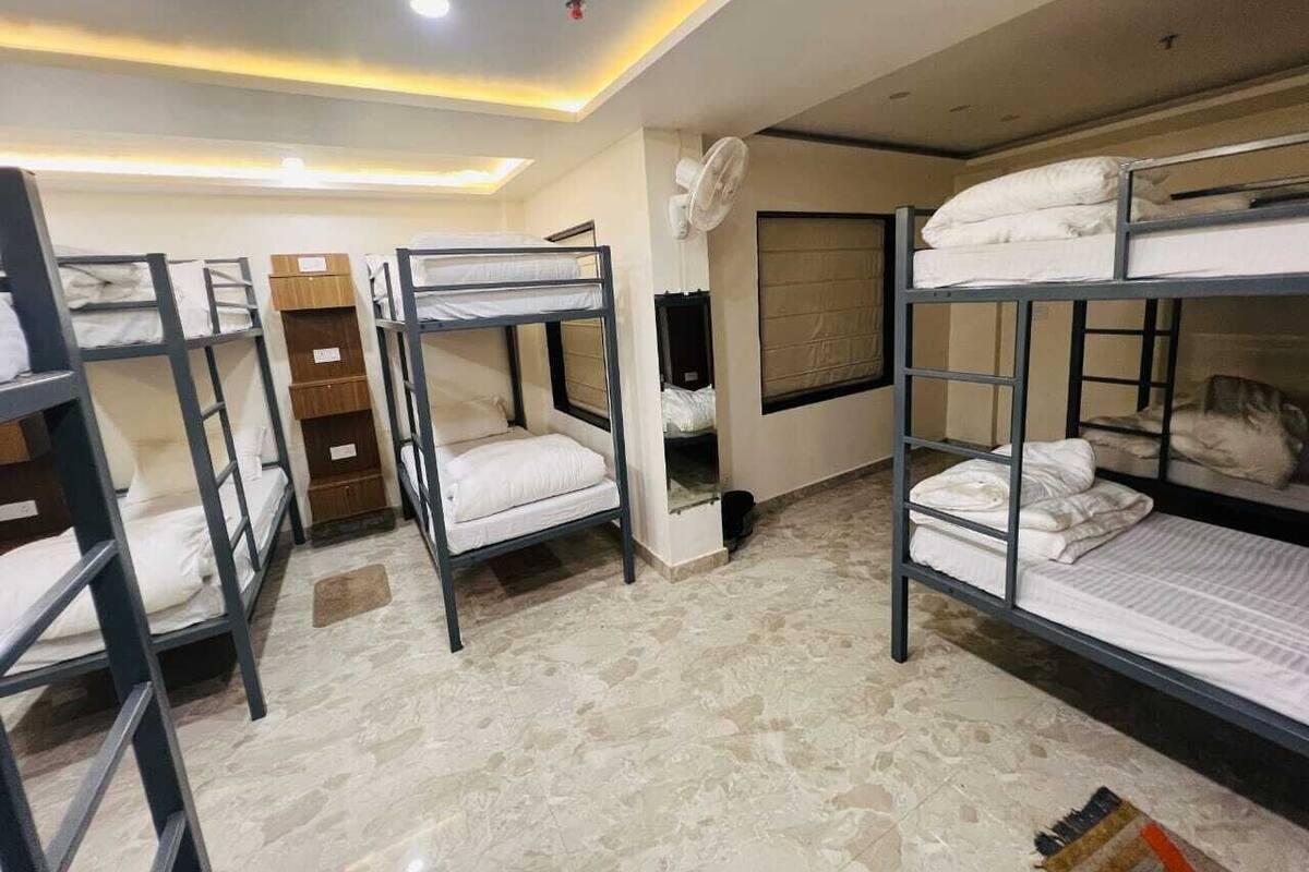 Un dormitorio con literas, un ventilador y una ventana.