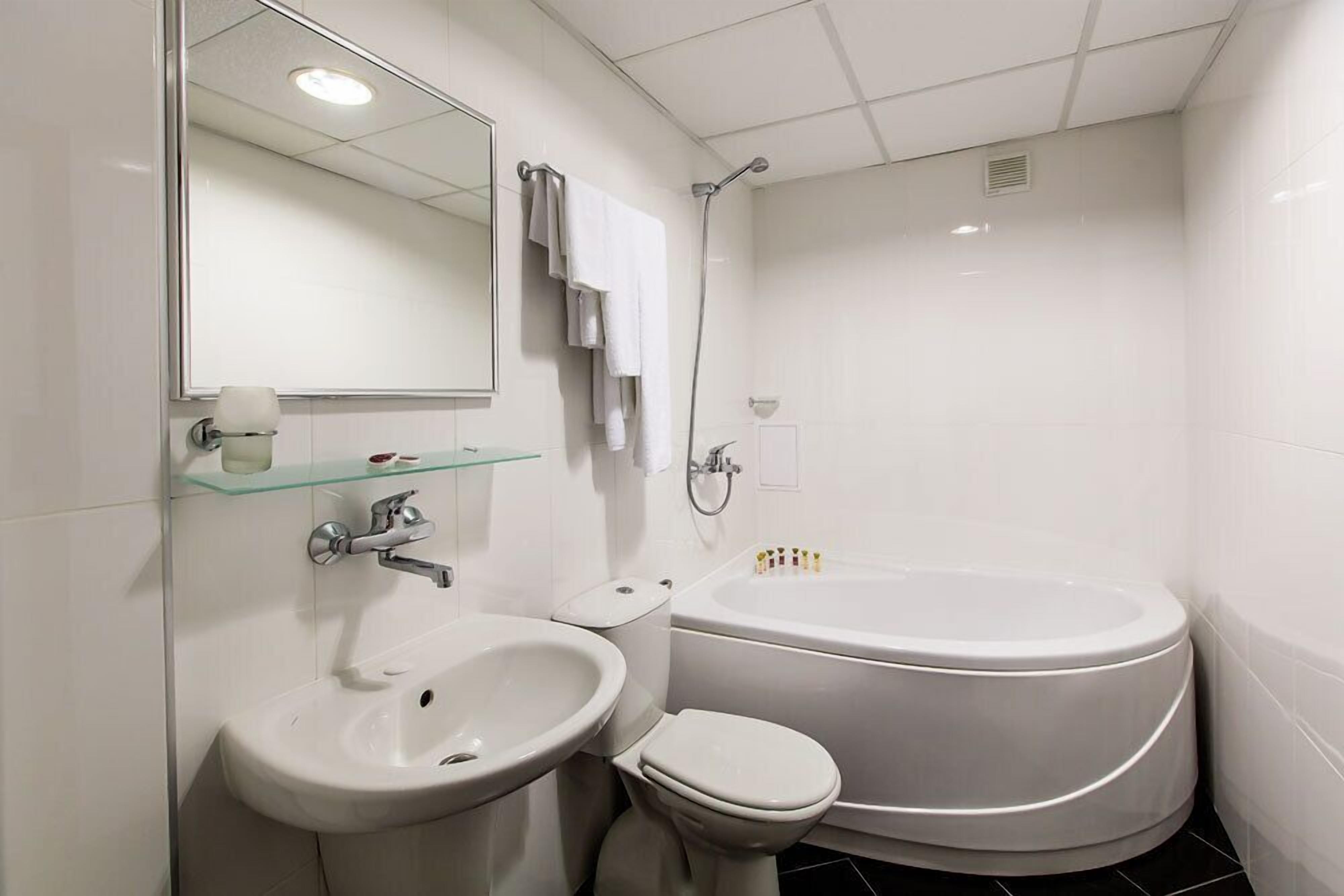 A modern bathroom with a sink, toilet, and bathtub.
