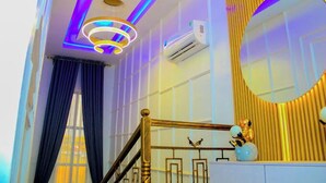 A modern interior with a staircase, a circular mirror, and a decorative sculpture.