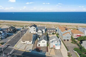 Una zona residencial costera con casas, una playa y una vista despejada del océano.