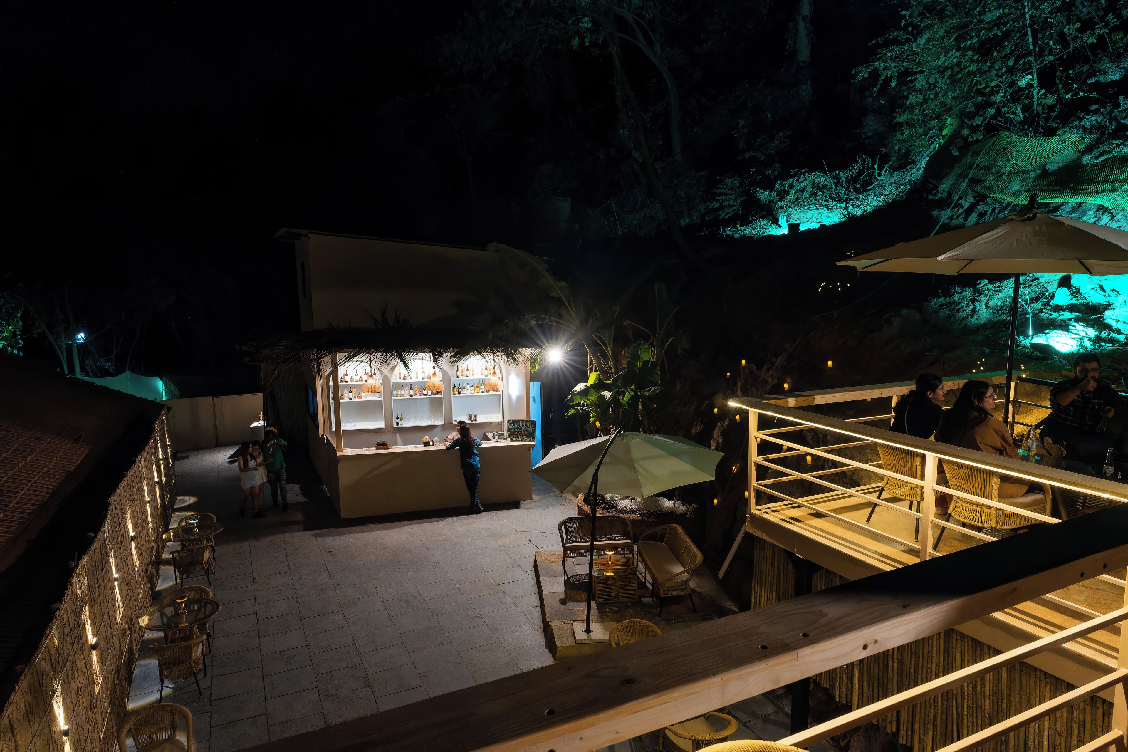 Un área de bar al aire libre con asientos y una barra.