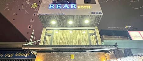 The exterior of the Bear Hotel with a modern design, featuring a prominent sign and a well-lit entrance.