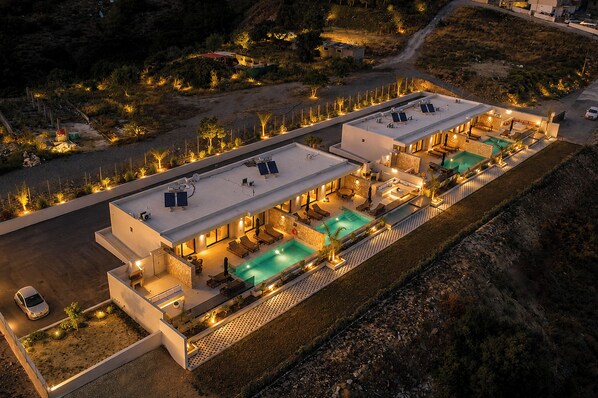 A modern hotel with a rooftop pool, outdoor seating, and a well-lit patio area.