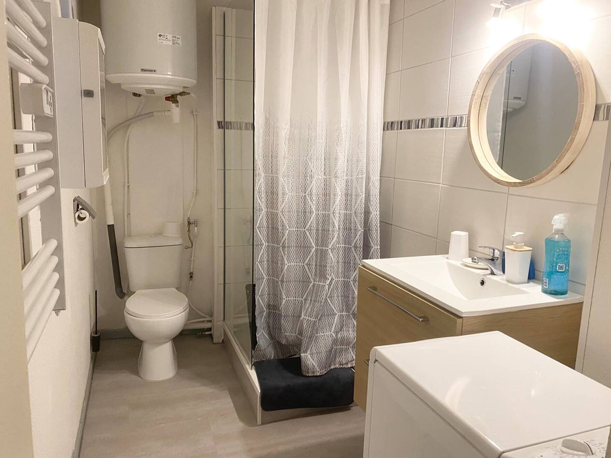 Une petite salle de bain comprenant des toilettes, une douche et un lavabo.
