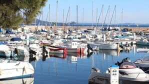 Un puerto deportivo con numerosas embarcaciones amarradas, agua tranquila y cielo despejado.