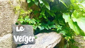 A stone sign with the inscription "Le Verger" in a natural setting with lush greenery. - QUINTA DE RIBAS - LE VERGER - SMALL CHARMING GITE (vila cha do marao, amarante)
